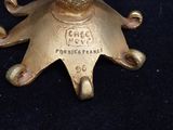 a gold star shaped candle holder on a black surface