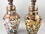 two vases with lids decorated with flowers and birds on them
