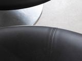 a black leather chair and a round table in a room