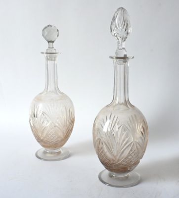 pair of antique cut glass decanters on pedestals on a white background
