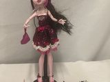 a doll that is standing next to a cake
