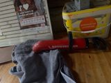 un outil rouge posé sur un plancher en bois près d'une fenêtre