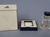a small bottle of perfume next to a small box