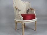 une chaise blanche sur laquelle est posé un coussin rouge