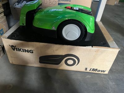 a green toy car sitting in a box on the floor