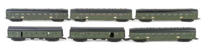 six green train cars are lined up on a white surface