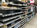 many empty shelves in a grocery store with food on them