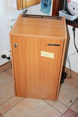 an image of a small wooden cabinet in the corner of a room