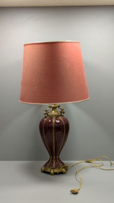 une lampe posée sur une table, avec un abat-jour rose