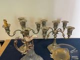 a silver candelab and a glass cup on a table