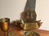une assiette en or et une coupe en argent posées sur une table en bois