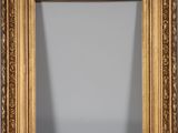 a gold framed mirror with a decorative design