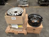 two rims and a wheel on a pallet in a warehouse