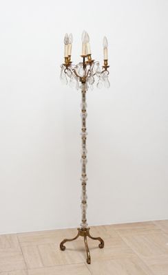 un lustre ancien en laiton à cinq branches posé sur un parquet
