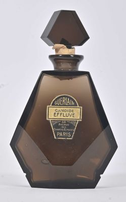 une image représentant un flacon de parfum posé sur une surface blanche