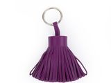 un porte-clés en cuir violet muni d'un anneau métallique et d'un pompon