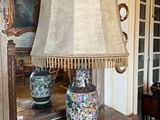 une table sur laquelle se trouve une lampe, avec un miroir en arrière-plan