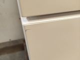 a white refrigerator sitting in the corner of a room