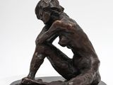 the statue of a man is sitting on a black base