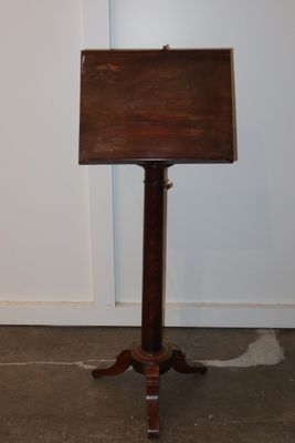 a small wooden sign on a stand in a room