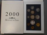an open book with a bunch of coins in it sitting on a table