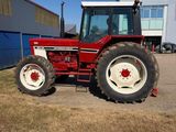 un tracteur rouge garé devant un bâtiment