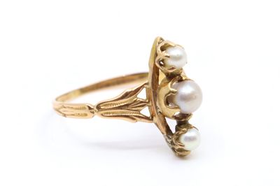 Gros plan sur une bague en or ornée de perles