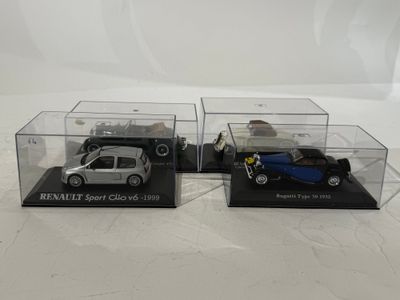two model cars in clear cases on a white surface