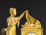 une horloge en or représentant une femme tenant un bébé dans ses bras