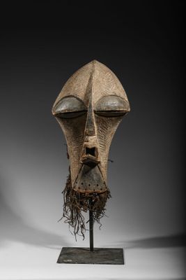 an image of a wooden mask on a stand on a white surface