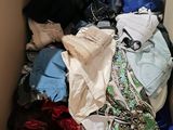 a cardboard box filled with clothes and clothing items