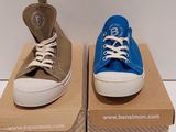 two pairs of blue and brown converses are on a cardboard box