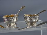 deux bols en argent avec des cuillères, posés sur une table
