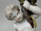 a statue of a boy holding a plant in his hand