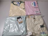 trois paires de t-shirts dans des sacs en plastique posés sur une table