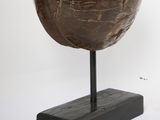 a wooden bowl on a black stand on a white background