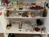 une étagère blanche sur laquelle sont posés de nombreux objets, dans la cuisine
