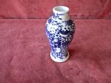 a blue and white vase sitting on a red cloth