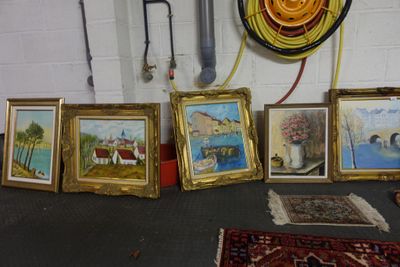 many paintings on the floor in a room