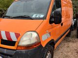 an orange van parked in a gravel lot with trees in the background