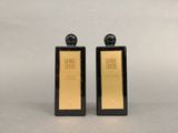 deux flacons de parfum noirs et dorés posés sur une table