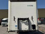 un camion blanc garé sur un parking avec d'autres camions