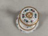 a small white and gold box with flowers on it
