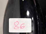 une bouteille de vin posée sur une étagère à côté d'une autre bouteille de vin