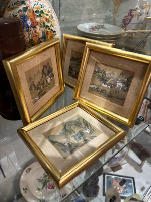 trois photos encadrées exposées dans une vitrine