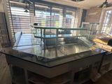 a kitchen island with a glass counter top and a wooden floor