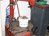 a red machine with a bucket on it in a garage