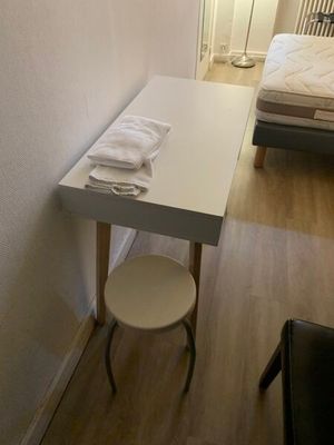 une petite table avec un tabouret dans un coin de la pièce