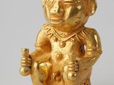une figurine en or représentant un singe assis sur une chaise