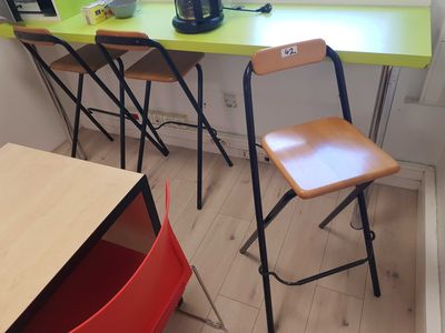a green table with two chairs and a laptop on it